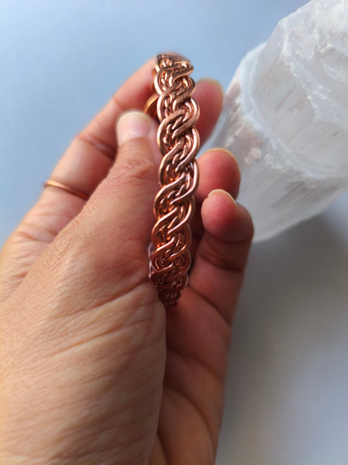 Pormenor do entrelaçado de fios da pulseira artesanal de cobre