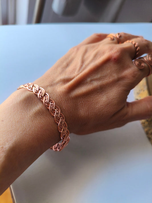 Pulseira artesanal de cobre entrelaçado usada no pulso